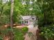 Charming two-story home with a well-manicured lawn and a long driveway surrounded by lush greenery and trees at 103 Red Cedar Pl, Chapel Hill, NC 27514