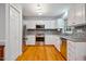 Modern kitchen with stainless steel appliances, white cabinets, hardwood floors, and stone countertops at 103 Red Cedar Pl, Chapel Hill, NC 27514