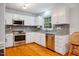 Well-lit kitchen featuring white cabinets, stainless steel appliances, and stylish backsplash at 103 Red Cedar Pl, Chapel Hill, NC 27514