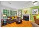 Cozy living room featuring a fireplace, large windows, hardwood floors, and comfortable seating area at 103 Red Cedar Pl, Chapel Hill, NC 27514