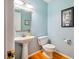 Small powder room with a pedestal sink, commode, and a blue accent wall at 103 Red Cedar Pl, Chapel Hill, NC 27514