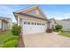 Close up of a two-car garage with carriage style doors, and a well-manicured lawn at 104 Spindle Dr, Durham, NC 27703