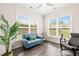 Comfortable living room with large windows, hardwood floors, a ceiling fan, and a blue loveseat at 104 Spindle Dr, Durham, NC 27703