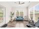 Bright living room with large windows, hardwood floors, a ceiling fan, and a blue loveseat at 104 Spindle Dr, Durham, NC 27703