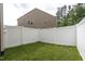 Backyard featuring well-maintained lawn and a white privacy fence for seclusion at 1048 Flagler St, Durham, NC 27713