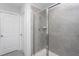 Bathroom with a glass-enclosed shower featuring gray tiling and a white door at 1048 Flagler St, Durham, NC 27713