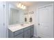Bright bathroom featuring a large mirror, gray cabinets, modern fixtures, and a door at 1048 Flagler St, Durham, NC 27713