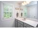 Bathroom with gray cabinets, a window letting in natural light, and a wide mirror above the sink at 1048 Flagler St, Durham, NC 27713