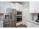 Bright white kitchen with stainless appliances including refrigerator, microwave, and oven at 1048 Flagler St, Durham, NC 27713