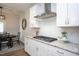 Bright kitchen with stainless hood over gas range, white cabinets, granite counters, and dining nook with table at 1048 Flagler St, Durham, NC 27713