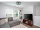 Cozy living room with sectional sofa, large windows, ceiling fan, and media center at 1048 Flagler St, Durham, NC 27713