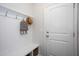 Bright mudroom with coat hooks, bench, and storage baskets, leading to a white front door at 1048 Flagler St, Durham, NC 27713