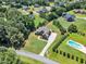 Aerial view of a beautiful property with mature trees, swimming pool, manicured lawn, and long driveway at 105 Somerley Dr, Garner, NC 27529