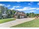 Rear exterior view showcasing a brick home with an expansive driveway and three-car garage at 105 Somerley Dr, Garner, NC 27529