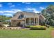 Stunning brick home featuring a covered porch, stone patio and lush landscaping in the backyard at 105 Somerley Dr, Garner, NC 27529
