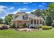 Beautiful backyard featuring a covered porch, brick patio with a fire pit, and well-manicured lawn at 105 Somerley Dr, Garner, NC 27529