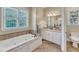 Bathroom with a white soaking tub and dual vanity with granite countertops at 105 Somerley Dr, Garner, NC 27529