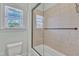Tiled bathtub and shower area with glass doors and bright window at 105 Somerley Dr, Garner, NC 27529