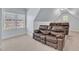 Bonus room with angled ceiling featuring comfortable leather theater seating near bright windows at 105 Somerley Dr, Garner, NC 27529