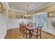 Formal dining room boasts wainscoting, beautiful windows, and a decorative chandelier, perfect for entertaining at 105 Somerley Dr, Garner, NC 27529