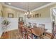 Elegant dining room featuring wainscoting, chandelier, and hardwood floors, ideal for Gathering gatherings at 105 Somerley Dr, Garner, NC 27529