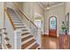 Elegant foyer featuring hardwood floors, a staircase with white railings, and natural light at 105 Somerley Dr, Garner, NC 27529