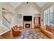 Living room with a fireplace, vaulted ceiling, built-in shelving, and hardwood floors is the perfect space to relax at 105 Somerley Dr, Garner, NC 27529