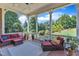Relaxing covered porch with comfortable seating, ceiling fan, and scenic views of the wooded backyard at 105 Somerley Dr, Garner, NC 27529
