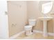 Half bathroom features a pedestal sink, toilet, and round mirror with good lighting at 110 Elmsford St, Durham, NC 27707