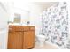 The bathroom has a vanity with a wood cabinet, a toilet, and a tub with a patterned shower curtain at 110 Elmsford St, Durham, NC 27707