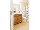 This bathroom has a toilet, a vanity with a wood cabinet, and a tub with a patterned shower curtain at 110 Elmsford St, Durham, NC 27707