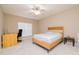 Bright bedroom features wooden bed frame, desk, ceiling fan, and neutral walls and carpet at 110 Elmsford St, Durham, NC 27707