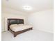 This bedroom features neutral walls, carpet, and a large bed frame with a modern upholstered headboard at 110 Elmsford St, Durham, NC 27707