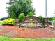 Landscaped Ashton Hall community entrance sign with stone pillars, beautiful plants, and American flags at 110 Elmsford St, Durham, NC 27707