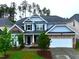 Beautiful two-story home featuring stone accents, a two-car garage, manicured lawn, and lush landscaping at 110 Elmsford St, Durham, NC 27707