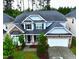 Aerial view of a charming two-story home with stone accents, manicured lawn, and an attached garage at 110 Elmsford St, Durham, NC 27707