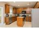 Well-lit kitchen featuring stainless steel appliances, granite countertops, a center island, and light brown cabinetry at 110 Elmsford St, Durham, NC 27707