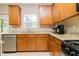 Kitchen view showcasing stainless steel dishwasher and sink, granite countertops, window, and warm wood cabinets at 110 Elmsford St, Durham, NC 27707
