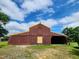 Expansive barn with yellow trim and a symbolic red accent piece on a sunny day at 111 Matthews Mill Pond Rd, Angier, NC 27501