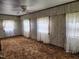 Bright bedroom with wood-paneled walls, brown carpet and multiple windows with lace curtains at 111 Matthews Mill Pond Rd, Angier, NC 27501