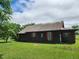 Quaint one-story cabin featuring a brown metal roof and a spacious green lawn at 111 Matthews Mill Pond Rd, Angier, NC 27501