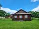 Quaint cabin featuring a brown exterior, a metal roof, and surrounding greenery at 111 Matthews Mill Pond Rd, Angier, NC 27501