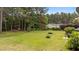 View of a large backyard, showcasing its well-maintained lawn and wooded backdrop at 11233 Jeffreys Ln, Wake Forest, NC 27587