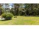 Spacious backyard with lawn, mature trees, and partial view of the home's patio area at 11233 Jeffreys Ln, Wake Forest, NC 27587