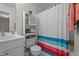 Bathroom with a sink, toilet, and cabinet, plus a striped shower curtain and a plant for added freshness at 11233 Jeffreys Ln, Wake Forest, NC 27587