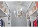 Elegant walk-in closet illuminated by a decorative chandelier, complete with organized shelves and clothing at 11233 Jeffreys Ln, Wake Forest, NC 27587