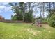 Spacious backyard with a playground, lush lawn, and a wooden fence, perfect for outdoor fun and relaxation at 1211 Whispering Oak Ln, Durham, NC 27704