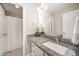 Bathroom with granite countertops, white cabinets, and a large mirror at 1211 Whispering Oak Ln, Durham, NC 27704