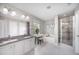 Bright bathroom featuring dual sinks, a soaking tub, and a glass-enclosed shower at 1211 Whispering Oak Ln, Durham, NC 27704