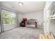 Bedroom with a crib, toys, and a large window overlooking the yard at 1211 Whispering Oak Ln, Durham, NC 27704